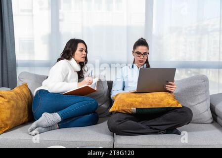 Two young colleagues college students of faculty of law, future lawyers study together as roommates preparing for educational exam using laptop comput Stock Photo