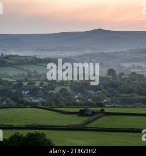 Morning mist rises from the Lyd valley near Brent Tor in the foothills of England's Dartmoor National Park. Stock Photo
