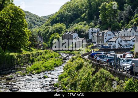 The East Lyn River flows through Lynmouth village in North Devon, with the hills of Exmoor behind. Stock Photo