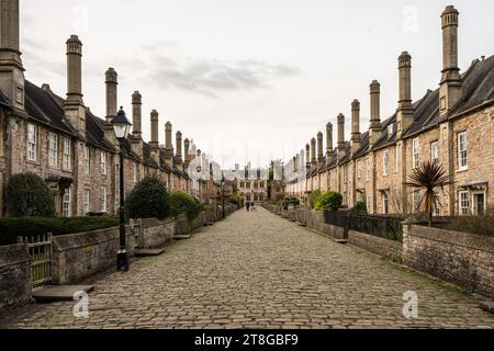 Traditional stone cottages line the quaint cobbled street of Vicars' Close in Wells, England. Stock Photo