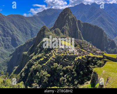 An aerial view of an Inca village situated against a backdrop of majestic mountain ranges of Machu Picchu, Peru Stock Photo