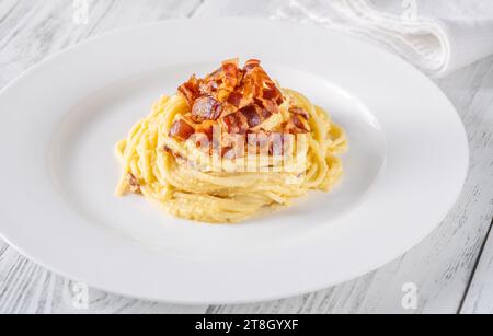Portion of carbonara pasta garnished with fried guanciale Stock Photo