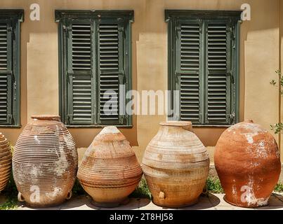 Four clay pots stand on an Athens sidewalk in front of a shuttered building. Stock Photo
