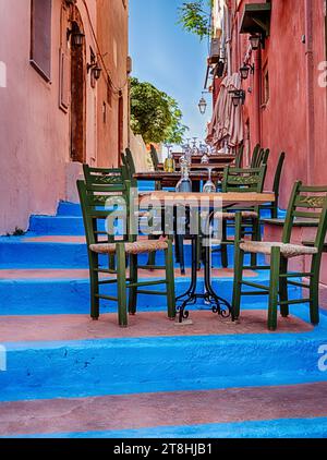 A small café is located in an alley with blue relief on the steps in Rethymno, Crete. Stock Photo