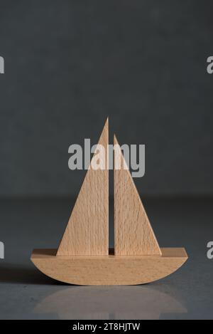 Wooden toy boat on grey background. Travel concept with copyspace on the top Stock Photo