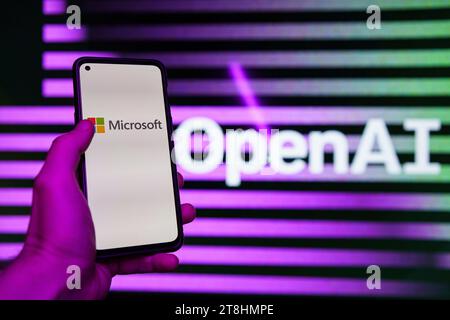 OpenAI logo and Microsoft logo in background displayed on the screens Stock Photo