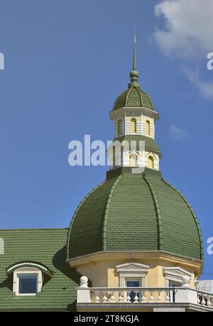 Completed perfect high-quality roofing work from metal roofing. The dome of a polyhedral shape with a spire is covered with green metal tiles Stock Photo