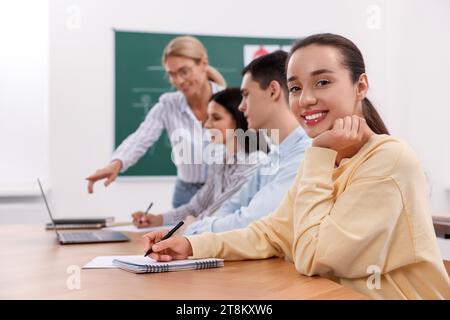 Happy woman making notes at desk in class during lesson in driving school Stock Photo