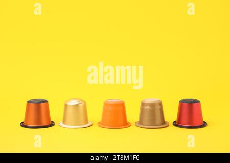 Many plastic coffee capsules on yellow background Stock Photo