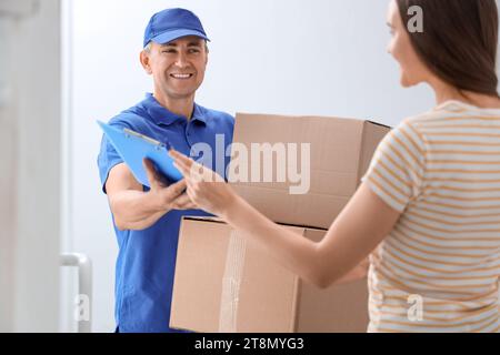 Young woman receiving parcels from courier in stairway Stock Photo