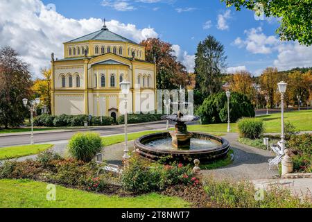 Fountain in front of the Church of the Assumption of Mary in the autumnal spa park, Marianske Lazne, West Bohemian Spa Triangle, Karlovy Vary Stock Photo