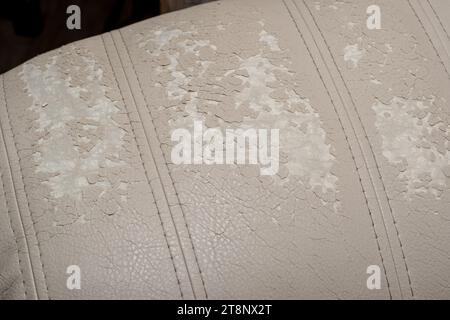 Defects on a white leather sofa. Damaged to leather furniture. Stock Photo