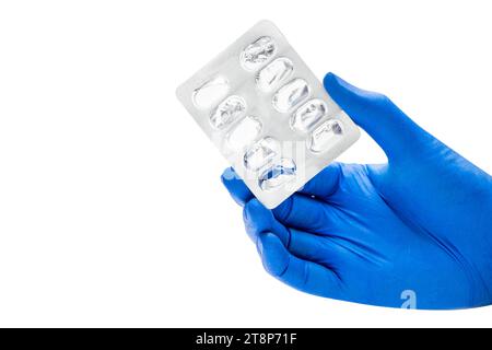 Hand with medical glove holding empty pill blister pack isolated over white background Stock Photo