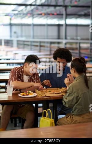Friends enjoying delicious pizza in outdoor cafe Stock Photo