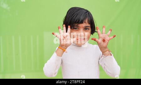 Cute little Indian girl smiling cheerful showing number five with fingers. Cute little girl having some great idea, concept of creativity. Stock Photo