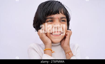 Happy Caucasian girl wearing striped T-shirt isolated over gray background touching face with two hands Stock Photo