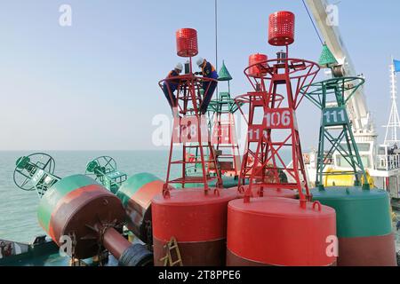 YANTAI, CHINA - NOVEMBER 21, 2023 - A worker installs a light for a beacon on the 'Haixun 153' navigation ship in Yantai, Shandong province, China, No Stock Photo