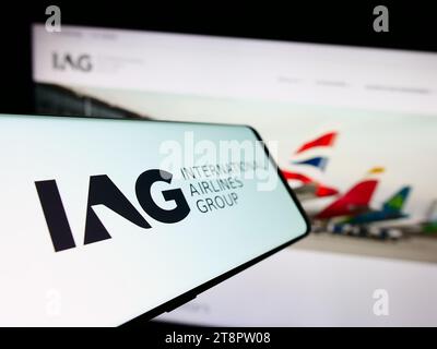 Smartphone with logo of International Consolidated Airlines Group SA (IAG) in front of business website. Focus on center-left of phone display. Stock Photo
