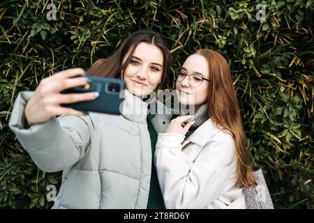 Gen Z influence on the development and popularity of short-form video content on social media platforms. Two girl friends share a moment over Stock Photo