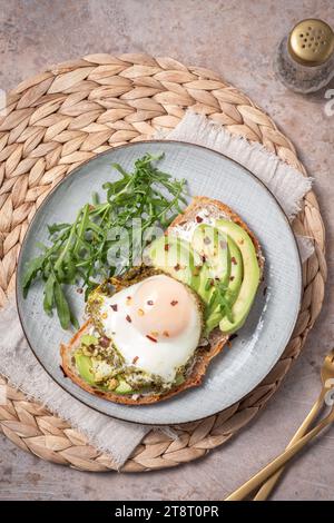 Avocado egg pesto sandwich. Healthy light breakfast concept. Whole grain toasts with avocado and fried pesto eggs Stock Photo