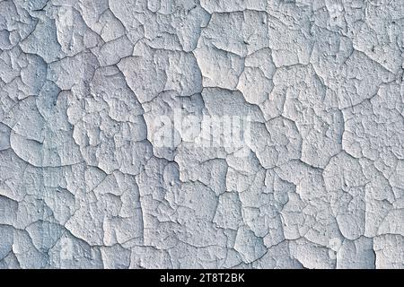 Close-up of old cracked plaster on brick wall on sunny day. Stock Photo