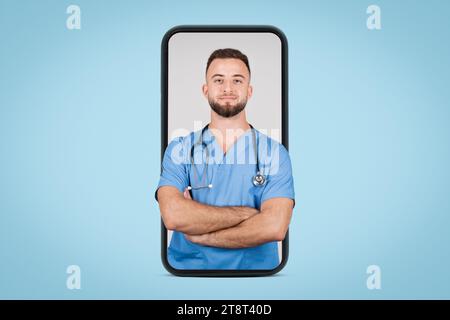 Male doctor in blue coat, arms folded, on huge phone screen, blue background Stock Photo