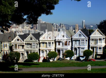 Painted ladies.San Francisco, One of the most photographed locations in San Francisco, USA, Alamo Square's famous 'postcard row' at Hayes and Steiner Streets is indeed a visual treat. A tight, escalating formation of Victorian houses is back-dropped by downtown skyscrapers, providing a stunning contrast. The grassy square itself is an ideal midday break. One of 11 historic districts designated by the Department of City Planning, the area includes several bed and breakfast inns Stock Photo