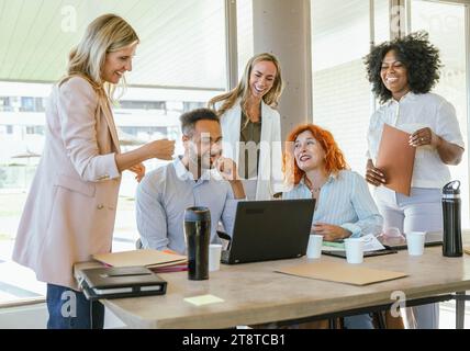 Multiethnic business coworkers smiling and having fun while working in the office. Business concept. Stock Photo