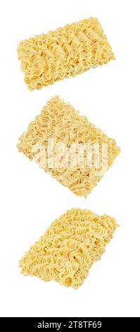 Instant noodles, raw briquettes, three pieces,  isolated on white background, falling, hanging, flying, soaring. Stock Photo