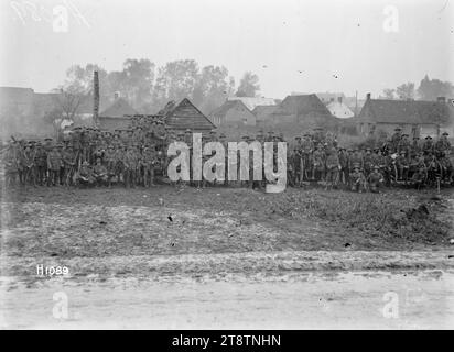 New Zealand Infantry with captured guns in Esnes, France, World War I, A large group of New Zealand Infantry soldiers pose with German guns captured during World War I. Many are sitting on the larger artillery pieces. A number of houses can be seen in the background. Photograph taken Esnes, France, 14 October 1918 Stock Photo