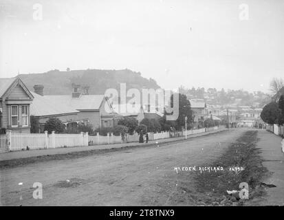 Burleigh Street, Mount Eden, Auckland, New Zealand, A view looking along Burleigh Street towards Mount Eden. A gas street lamp can be seen on the lefthand side of the street directly opposite the Baptist church. A woman and young girl are standing near the lamp-post looking at the photographer. in early 1900s Stock Photo