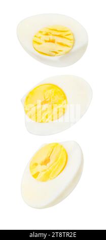 Boiled eggs, cut, three pieces,  falling, hanging, flying, soaring, isolated on white background with clipping path. Stock Photo