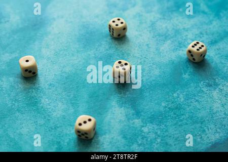 cream color dice on a blue watercolor background Stock Photo