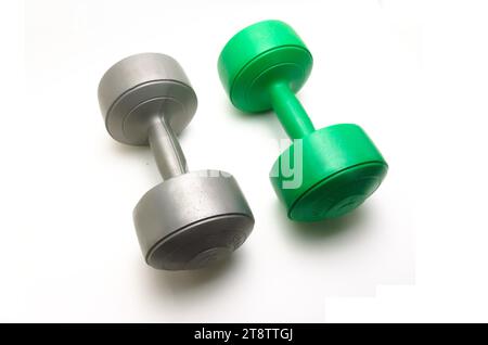 Two 5 kg dumbbell barbells in gray and green on a white background Stock Photo