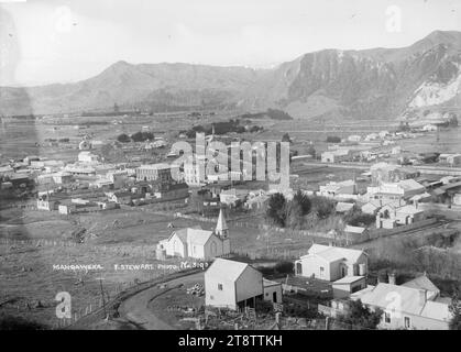 View looking down on Mangaweka township - Photograph taken by Frank Stewart, View from a hill above Mangaweka. A road in the foregound bends to the right, with a church on the left of the road, various commercial buildings centre left in the image, and several houses Stock Photo