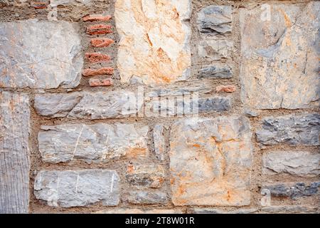 Wall from bricks, rectangular and square stones, texture of brown, yellow and red stone background texture. Stock Photo