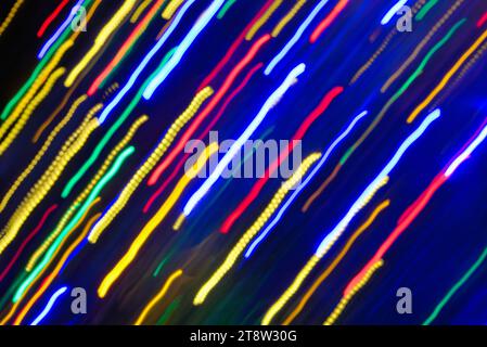 Blurred multi coloured light patterns streaks against a dark background creating abstract shapes Stock Photo