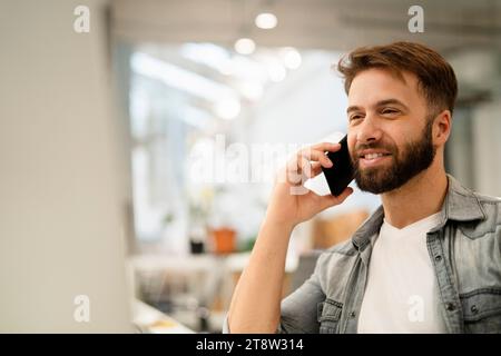 Male system engineer listening to voice mail while using computer Stock Photo