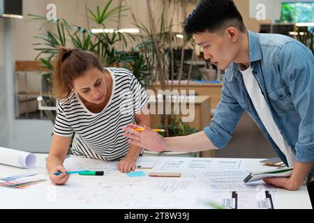 Architects discussing over blueprint while leaning on table Stock Photo