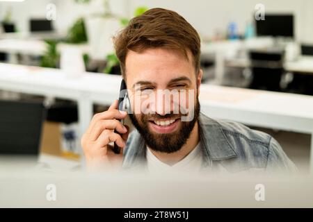 Male system engineer listening to voice mail while using computer Stock Photo
