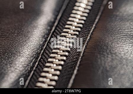Zipper closure with metal teeth, on faux leather jacket close-up, selective focus Stock Photo