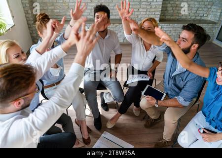 Happy diverse success business team celebrating success and having fun all together. Stock Photo