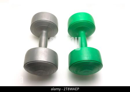 Two 5 kg dumbbell barbells in gray and green on a white background Stock Photo