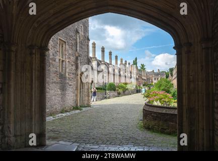 Looking through the waggon gate and archway in Vicars Hall at the entrance to Vicars close, adjacent to the cathedral in Wells, Somerset, England, UK Stock Photo