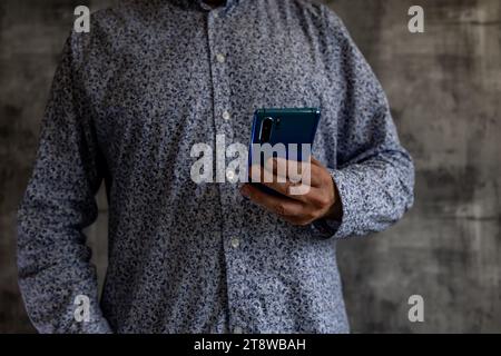 Unknown phone stalking phone bad news phone in man's hands scam dial number Stock Photo