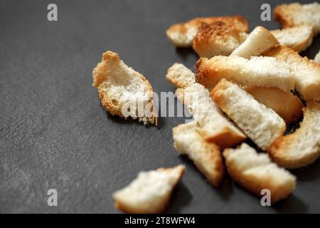 Crackers, dried baked bread pieces on dark background, selective focus. Stock Photo