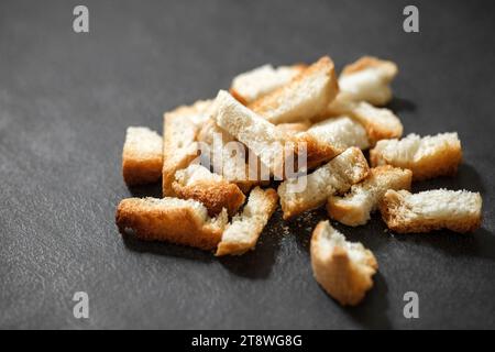 Crackers, dried baked bread white, bunch of broken on dark background, selective focus. Stock Photo