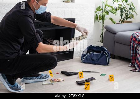 Forensics researcher photographing a blood stained knife at a murder scene Stock Photo