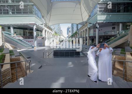 Arab men taking pictures at the Abdali Shopping Mall. A modern shopping mall next to Damac Tower condominium complex. Amman, Jordan Stock Photo