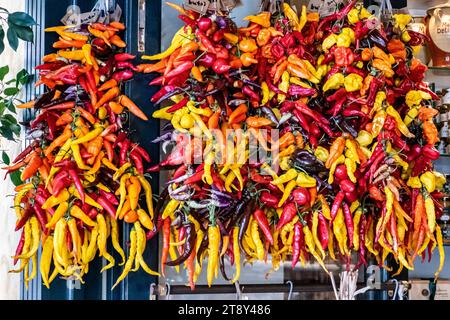 A bundle of different red chillies and red peppers hangs outside a delicatessen in Santanyi, Spain Stock Photo